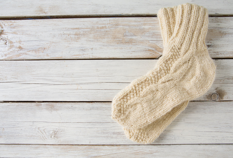 a pair of cream woolen socks