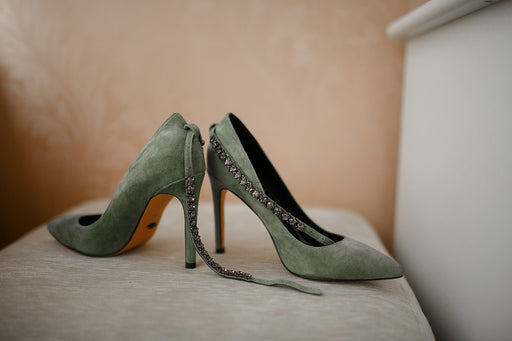 a pair of sage green stilettos with diamante ankle straps