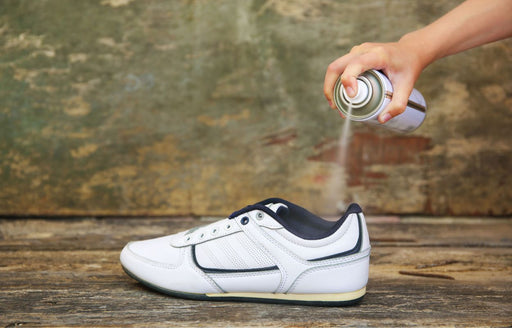 a sneaker being treated with a protector spray