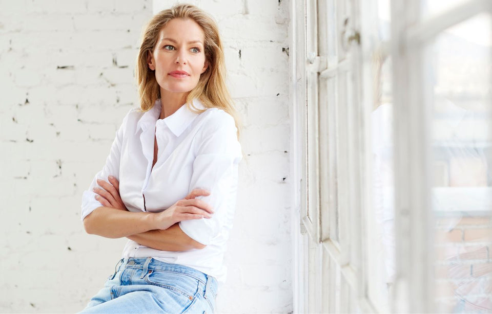 a woman in her fifties wearing a white shirt and denim jeans