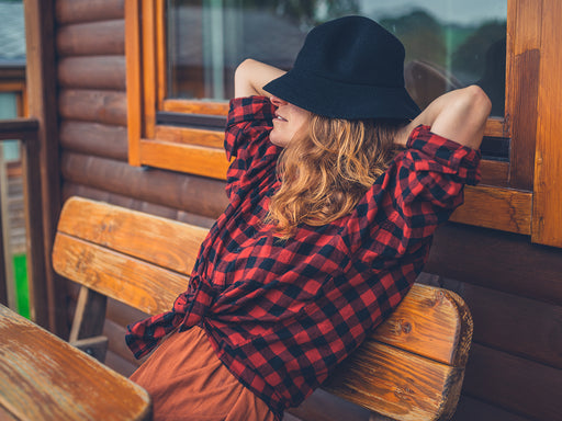 a woman relaxing in a red and black buffalo check shirt