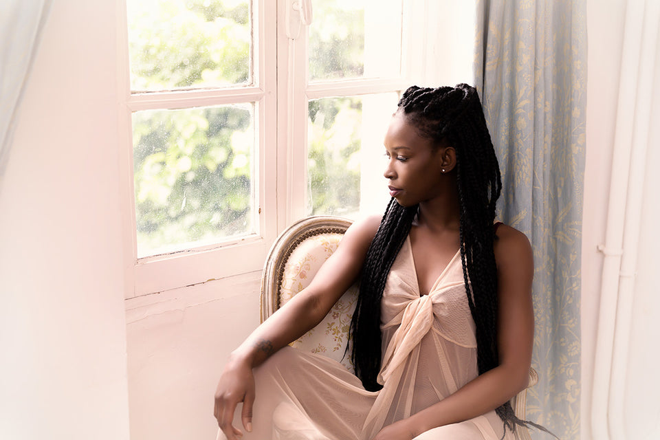 a woman sitting at her window in a beautiful long night dress