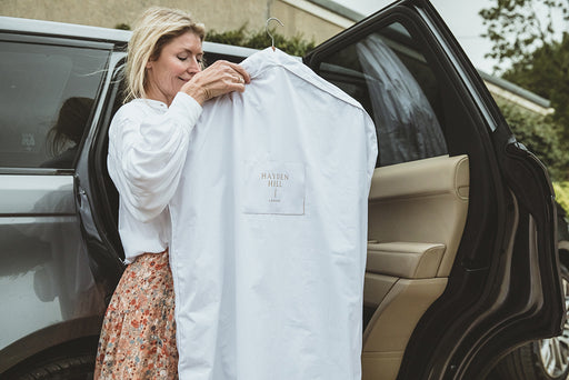 a woman taking her Hayden Hill 100% organic cotton Garment Bag out of the car
