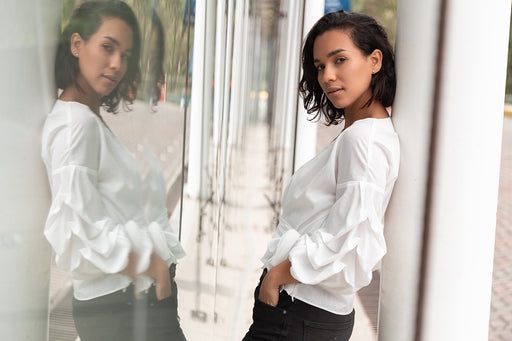 a woman wearing a stylish white shirt and black jeans, perfect to go from day to night