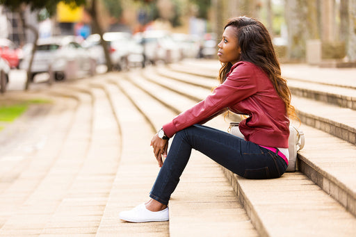 a woman wearing skinny dark jeans sitting on steps