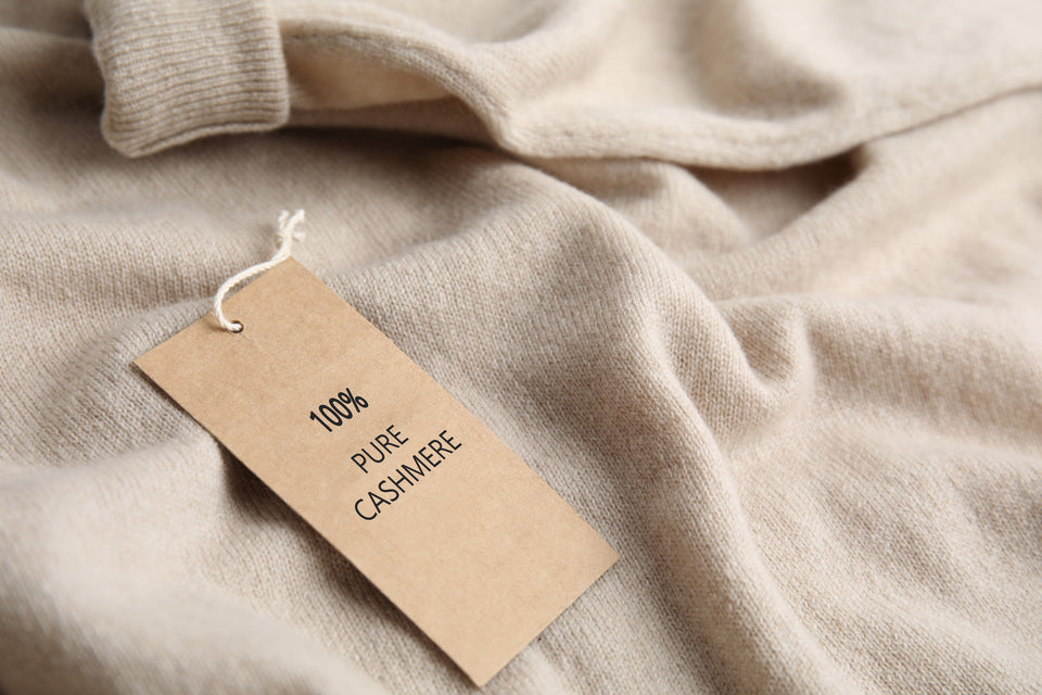 a beige cashmere sweater with a 100% cashmere label