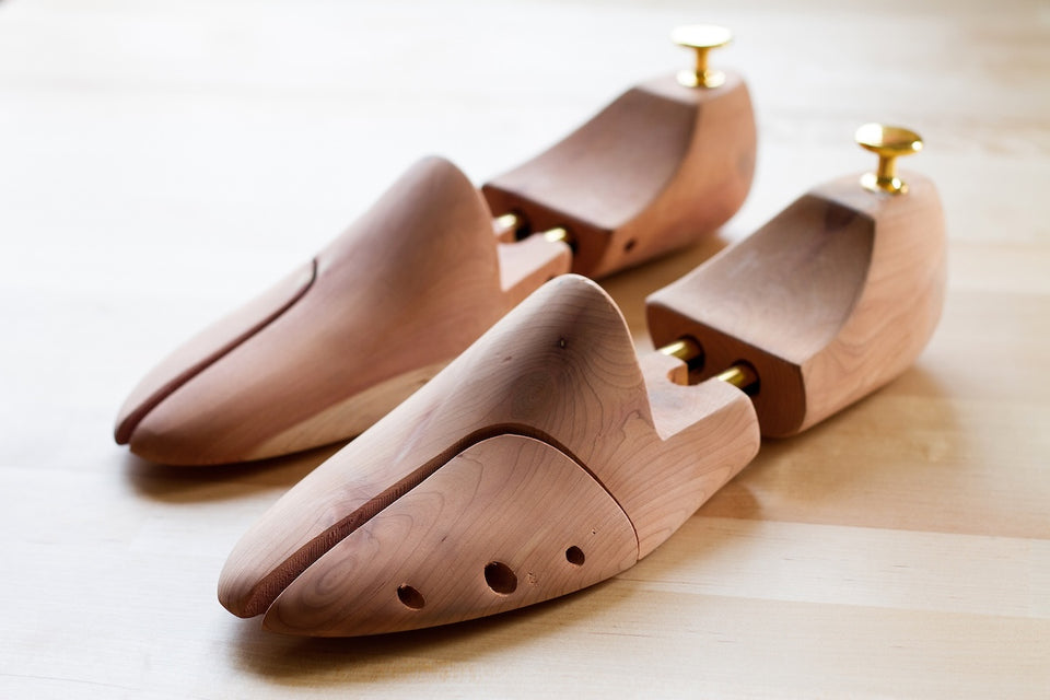 a close up of a pair of elegant cedar shoe trees for keeping sneaker in good condition