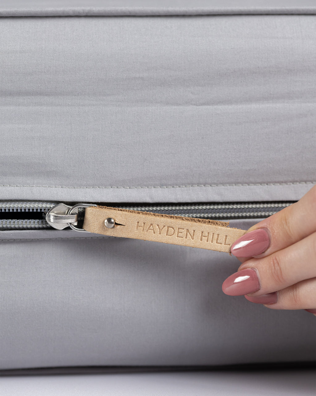 a close up of the grey storage bag with the leather zipper pull