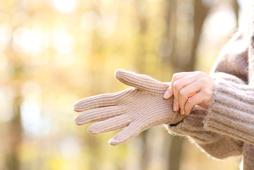 hands putting on warm woolen gloves