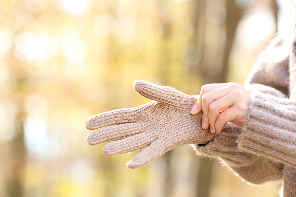 hands putting on warm woolen gloves