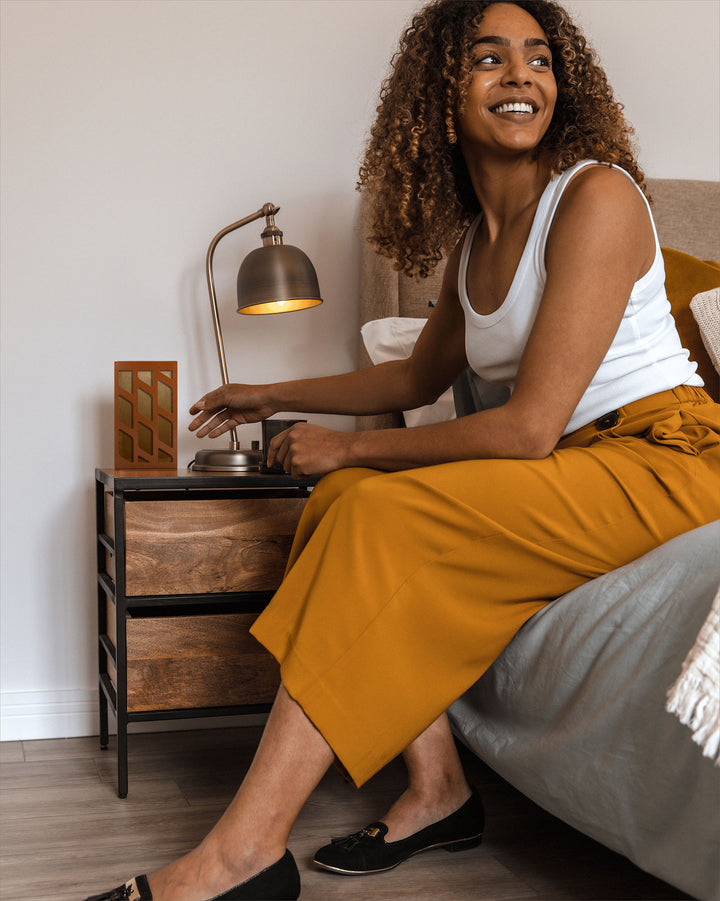 Woman placing moth trap on bedside table