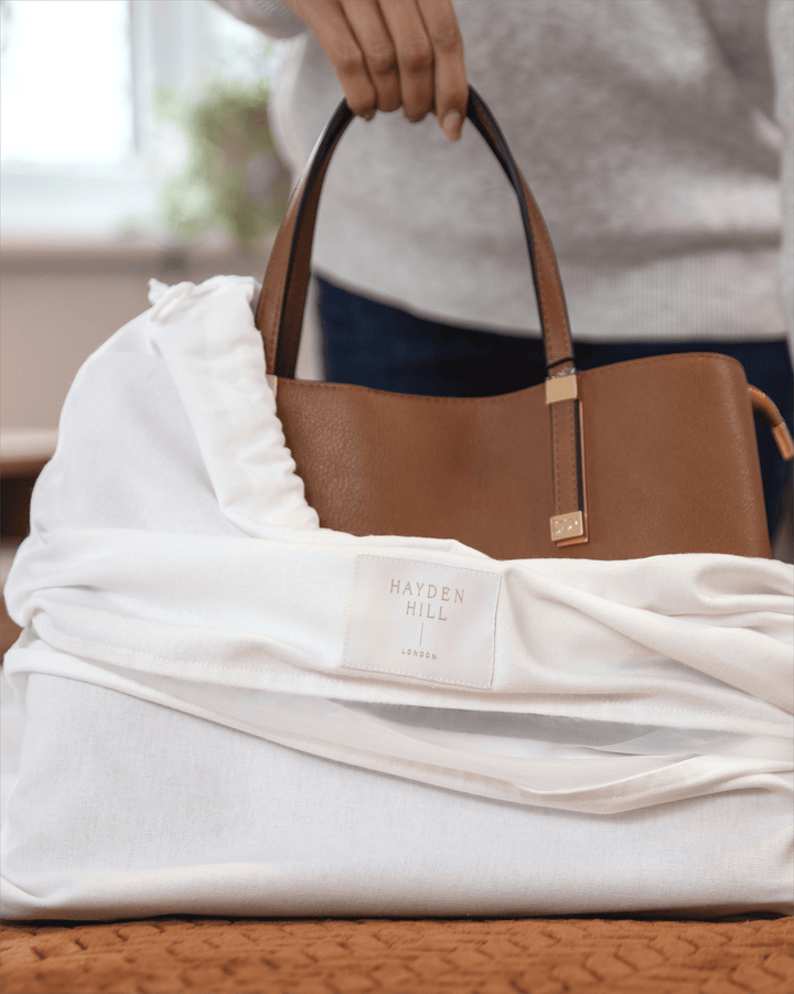 a handbag being put into a dust bag