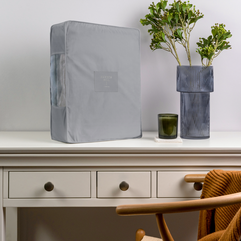 an extra large grey storage bag sitting on a dressing table