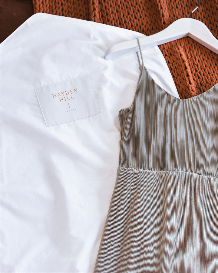 a Hayden Hill hanging bag lying on a woollen blanket next to a shoestring strap summer dress