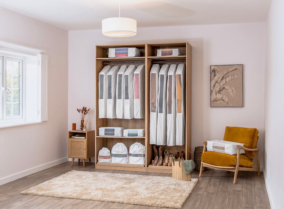 an open closet showing a selection of Hayden Hill organic cotton hanging storage and dust bags