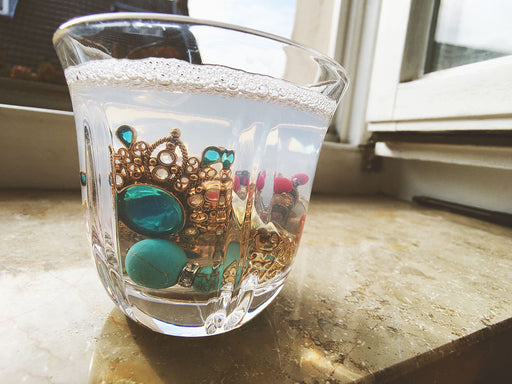 jewelry made from gold and semi precious stones being soaked in soapy water