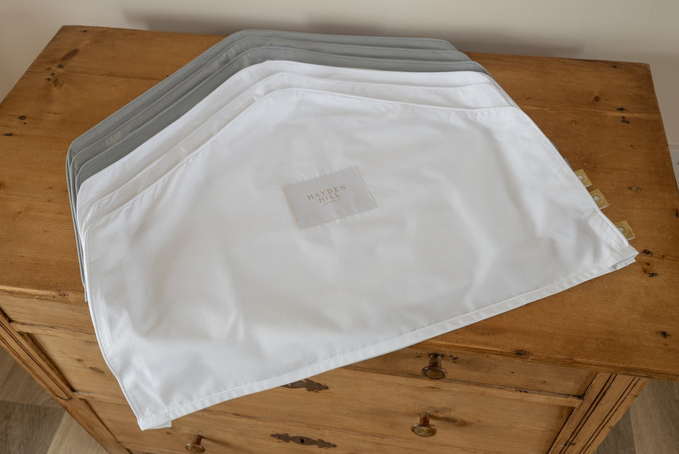 white and gray organic cotton shoulder dust covers on a chest of drawers