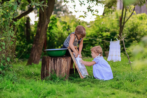 two children using a washboard to do their washing