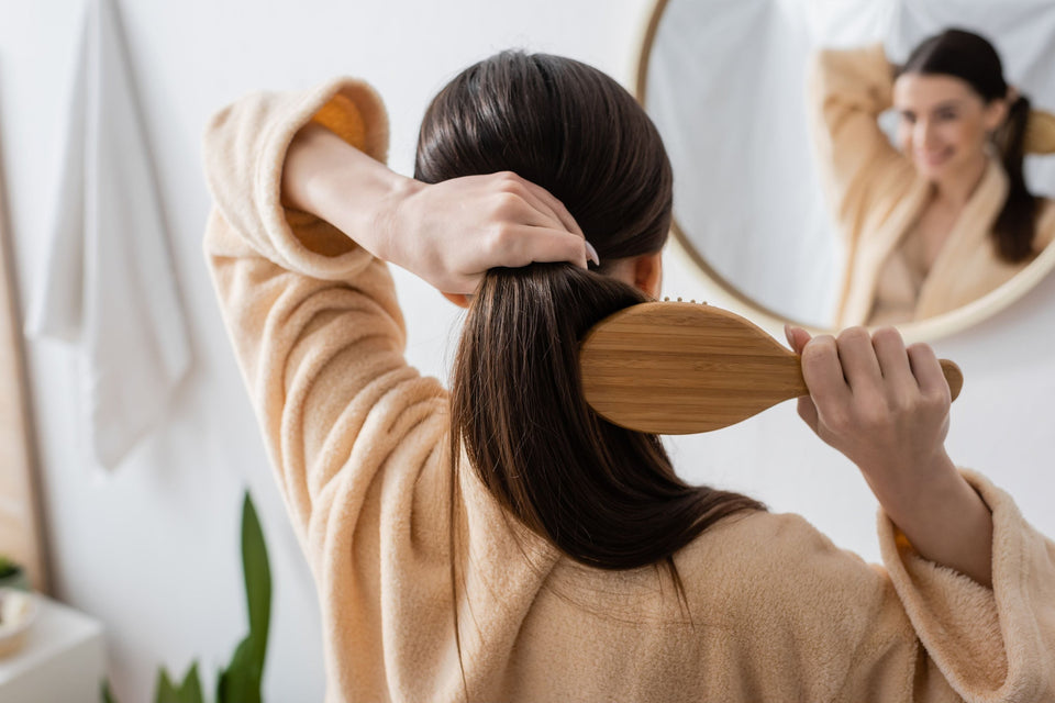 a woman brushing her beautiful shiny dark brown hair