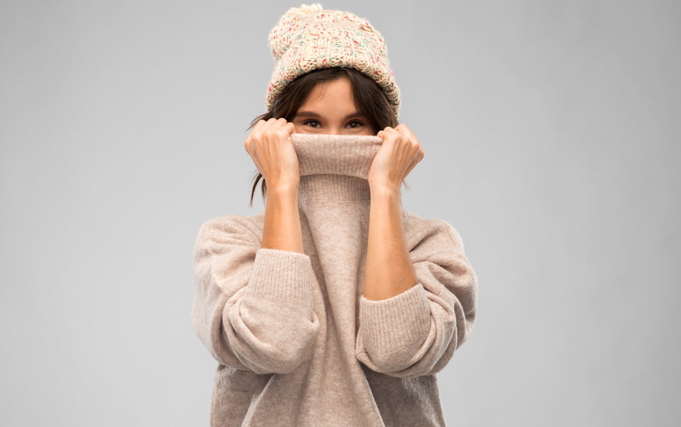 a woman in a cozy pullover and woolen hat