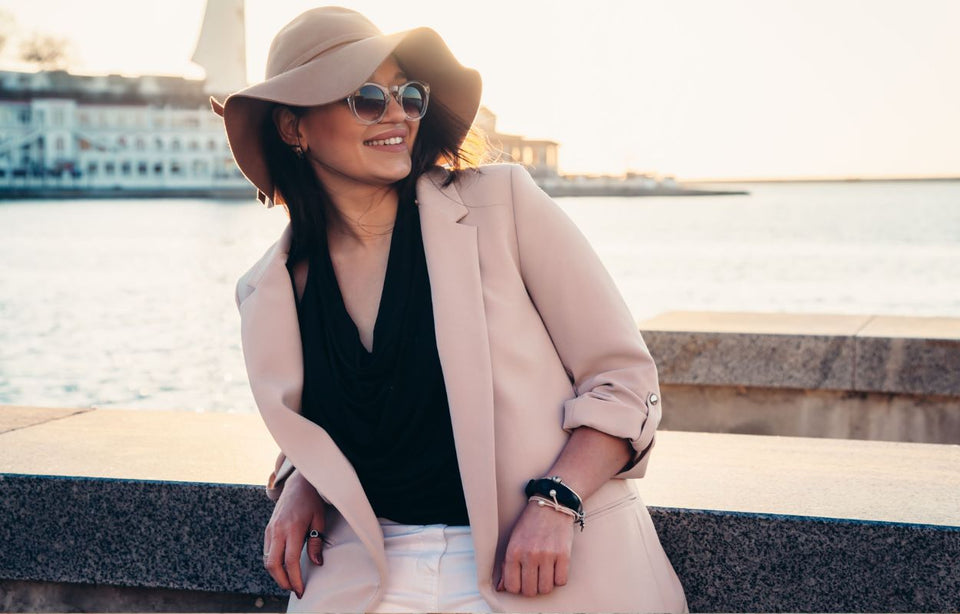 woman wearing a pastel pink blazer with a black top and white pants
